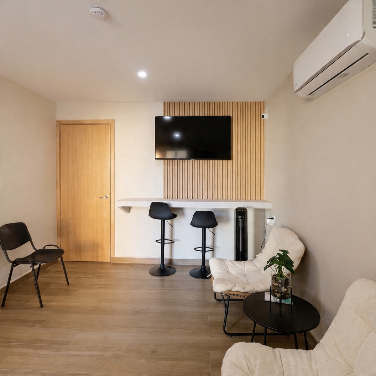 Sala de espera para acompañantes en Clínica Bital con televisión y área de descanso
